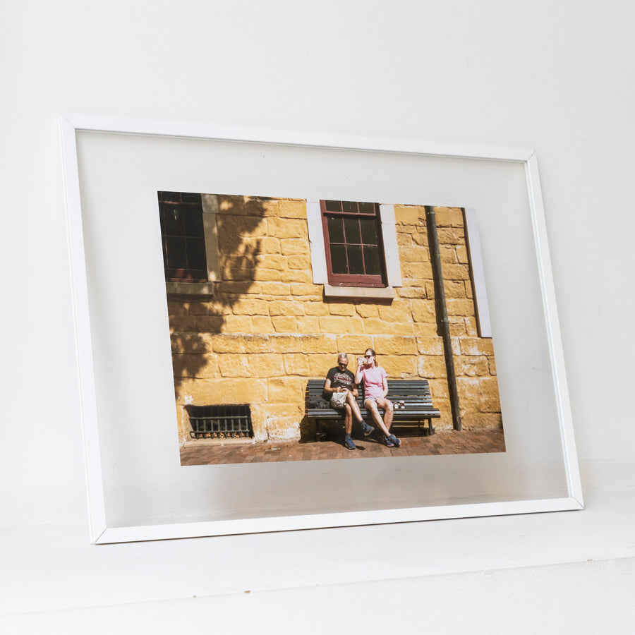 Two people resting on a bench / A3 wh frame